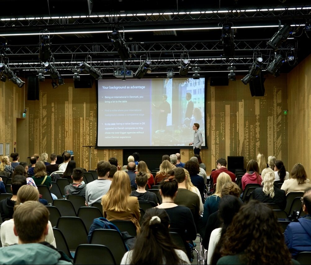 Vincent Stöber on stage delivering a keynote to an audience